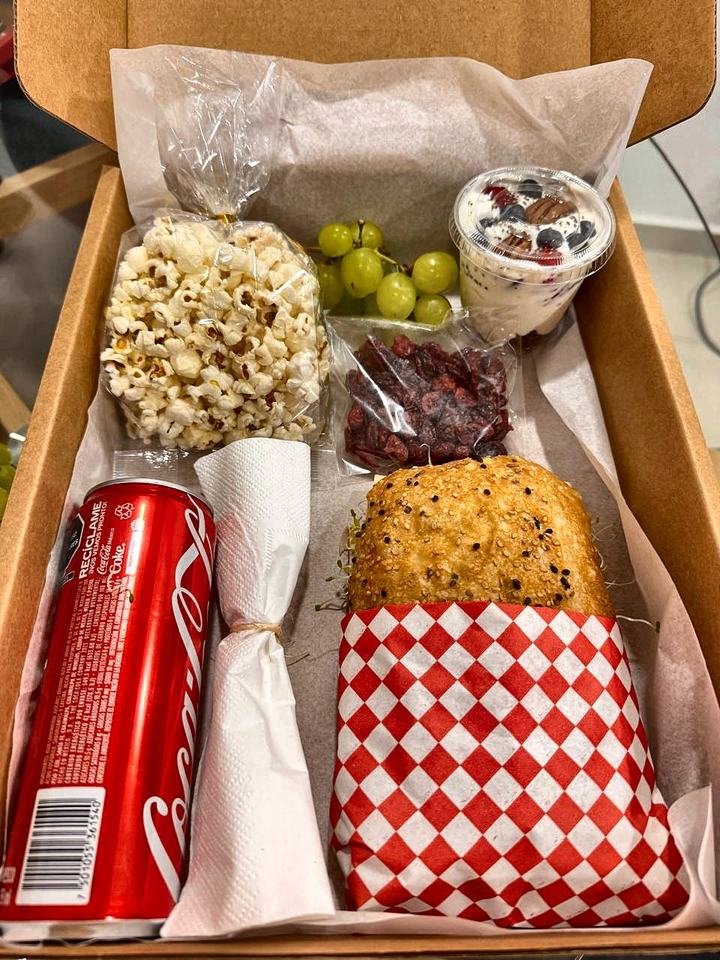Box lunch con sándwich, palomitas, uvas, arándanos y yogurt con fruta