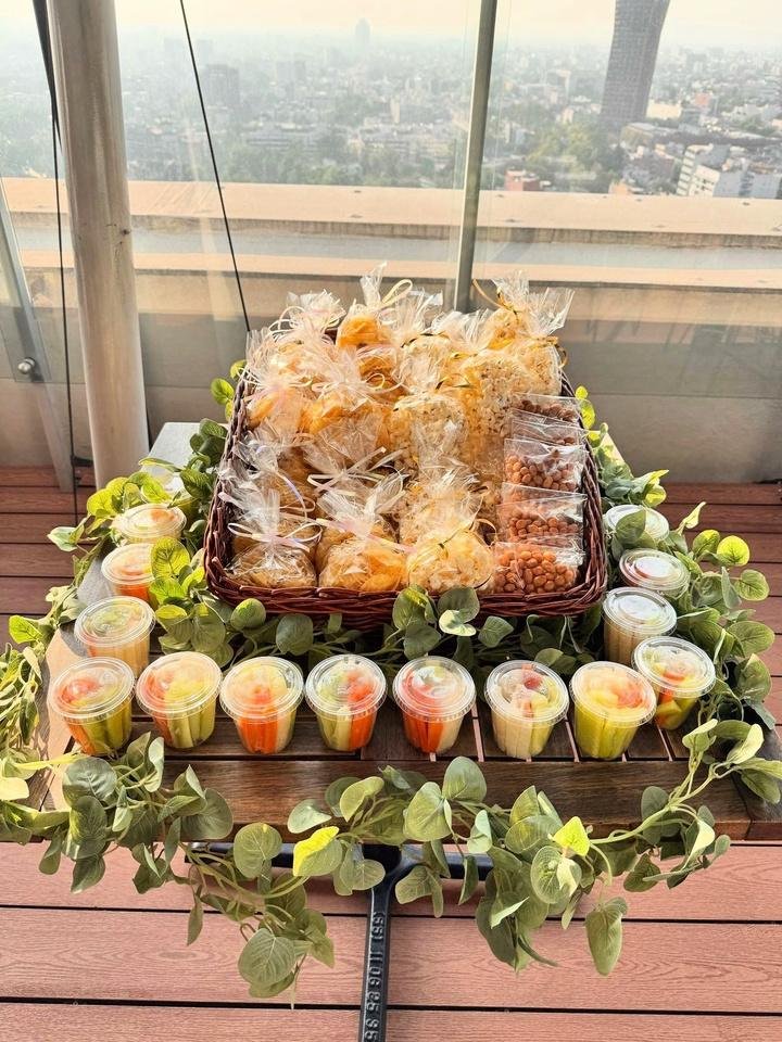 Mesa de snacks con bolsas de botana y vasos de fruta
