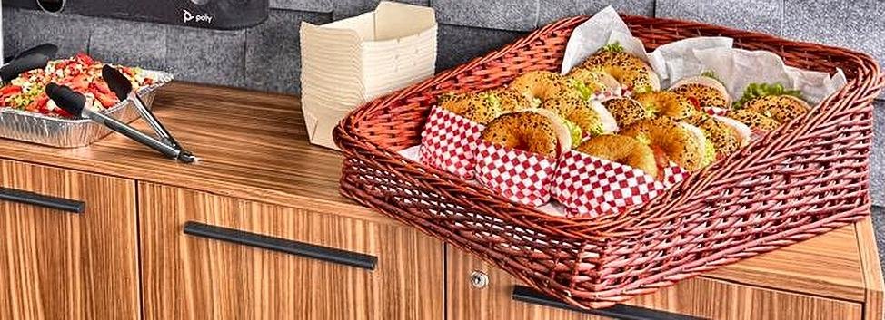 Canasta de bagels y ensalada servidos en sala de juntas